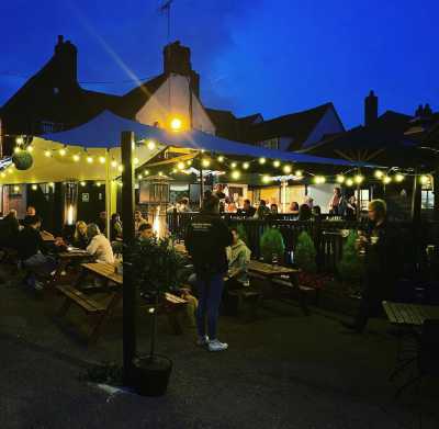 Many patrons in the White hart beautifully lit beer garden in the early evening