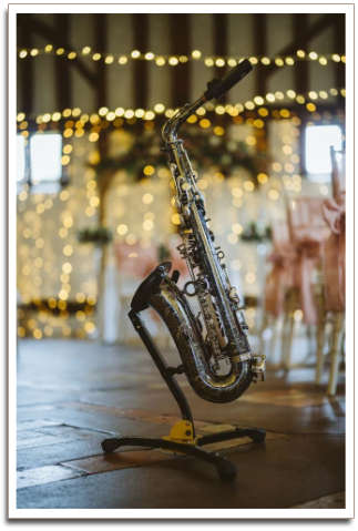 Saxaphone on stand inside with pretty lights behind