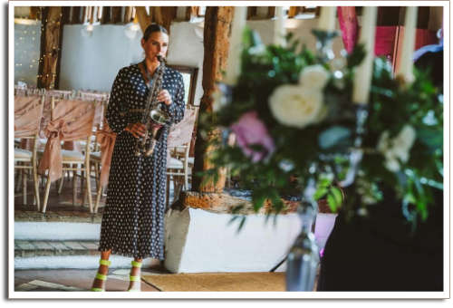 Kay with Sax in wedding Aisle wearing polka dot dress